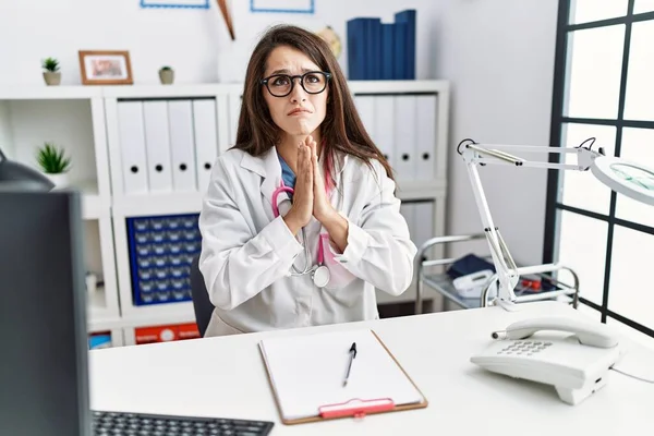 Jonge Doktersvrouw Doktersuniform Stethoscoop Kliniek Bedelend Biddend Met Handen Samen — Stockfoto