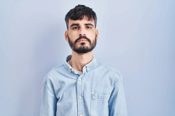 Mladý Hispánec Plnovousem Stojící Nad Modrým Pozadím Uvolnil Vážným Výrazem — Stock fotografie