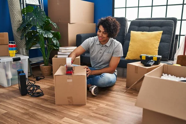 Young Hispanic Man Packing Package Sitting Floor New Home — Stock Photo, Image
