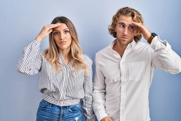 Young Couple Standing Blue Background Worried Stressed Problem Hand Forehead — Stock fotografie