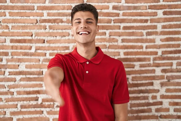 Joven Hombre Hispano Pie Sobre Pared Ladrillos Sonriente Amistoso Ofreciendo — Foto de Stock