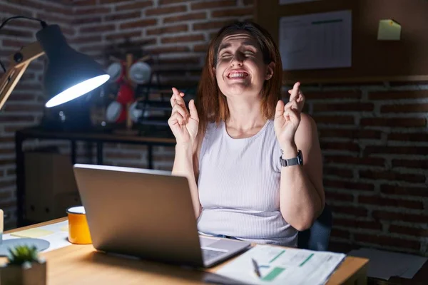 Brunette Woman Working Office Night Gesturing Finger Crossed Smiling Hope — 스톡 사진