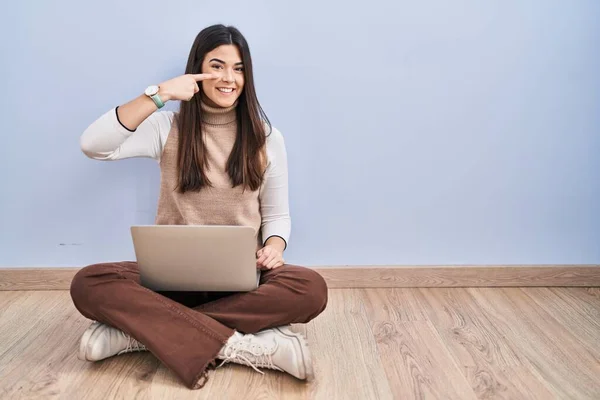 Молодая Брюнетка Работающая Ноутбуком Сидящая Полу Указывая Пальцем Лицо Нос — стоковое фото