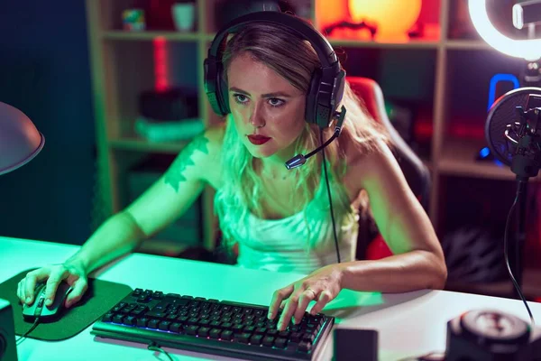 stock image Young beautiful hispanic woman streamer playing video game using computer at gaming room