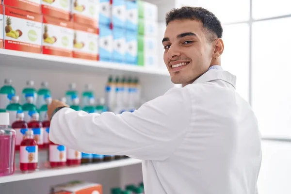 Joven Farmacéutico Hispano Sonriendo Confiado Organiza Estanterías Farmacia — Foto de Stock