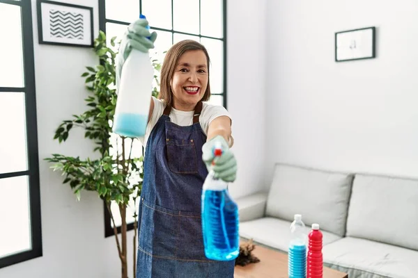 Middle Age Hispanic Woman Working Housekeeper Holding Products Home — Φωτογραφία Αρχείου