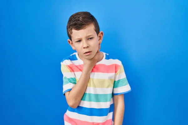 Mavi Arka Planda Dikilen Beyaz Bir Çocuk Ağrılı Boynuna Dokunuyor — Stok fotoğraf