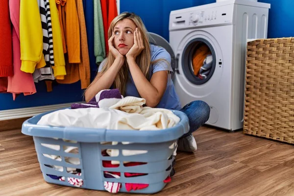 若いですブロンド女性不幸な洗濯服でランドリールーム — ストック写真