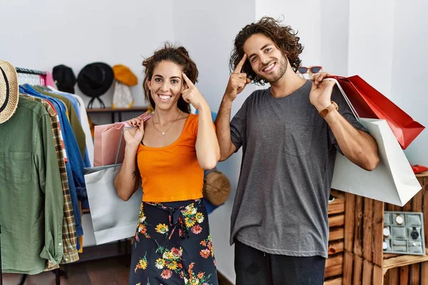 Junge Hispanische Paar Mit Einkaufstüten Einzelhandel Lächelnd Zeigt Auf Den — Stockfoto