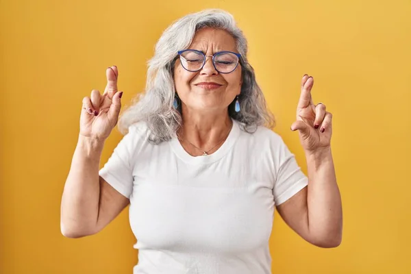 Sarı Arka Planda Gri Saçlı Orta Yaşlı Bir Kadın Umut — Stok fotoğraf