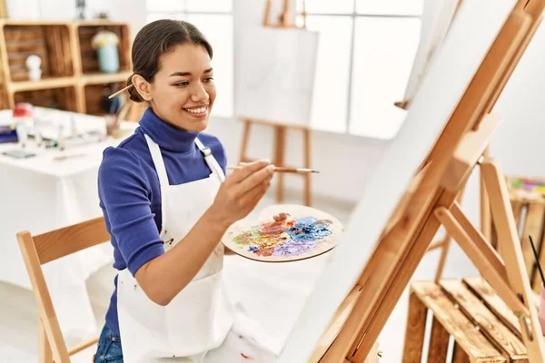 年轻的拉丁女子在艺术工作室微笑而自信地画画 — 图库照片