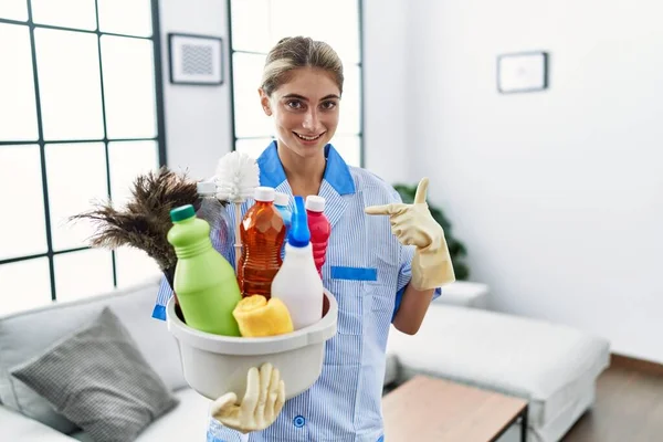 Mujer Rubia Joven Usando Uniforme Más Limpio Sosteniendo Productos Limpieza —  Fotos de Stock