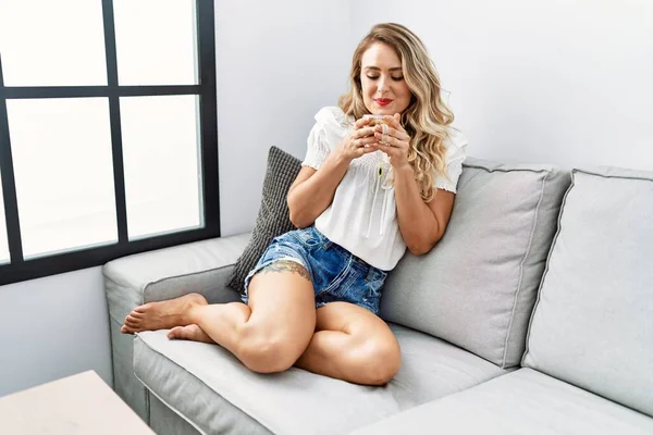 Young Woman Drinking Tea Sitting Sofa Home — Stok fotoğraf