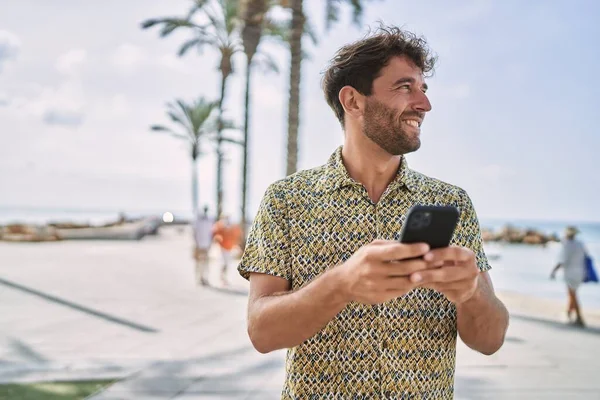 Ung Latinamerikansk Man Ler Säker Med Hjälp Smartphone Vid Havet — Stockfoto
