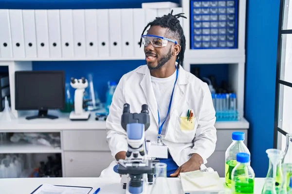 과학자 실험실에서 일하는 머리를 아프리카 스러운 자신감 미소로 포즈를 취하며 — 스톡 사진