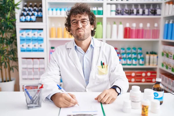 Joven Hispano Que Trabaja Farmacia Fumando Mejillas Con Cara Graciosa — Foto de Stock