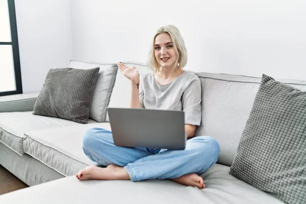 Genç Beyaz Kadın Evinde Dizüstü Bilgisayar Kullanıyor Kanepede Oturuyor Gülümsüyor — Stok fotoğraf