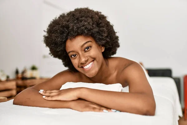 Młoda Afrykańska Kobieta Uśmiecha Się Pewnie Leżąc Stole Masażu Centrum — Zdjęcie stockowe