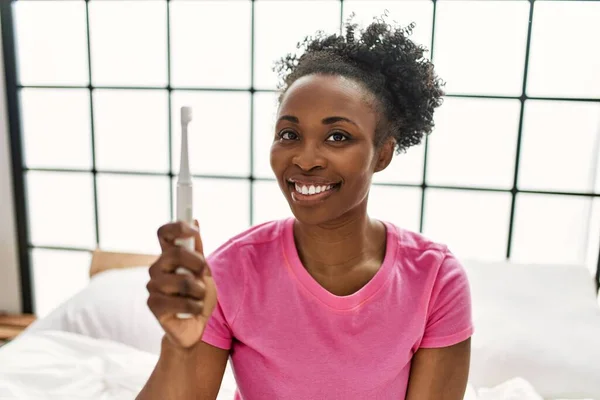 Африканская Американка Электрической Зубной Щеткой Сидит Кровати Спальне — стоковое фото