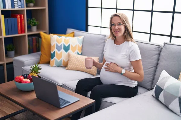 Jonge Zwangere Vrouw Met Laptop Drinken Koffie Thuis — Stockfoto