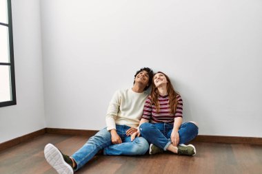 Genç İspanyol çift tavana bakıyor. Boş bir evde yerde oturuyorlar..