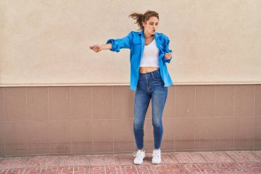 Young woman smiling confident dancing at street