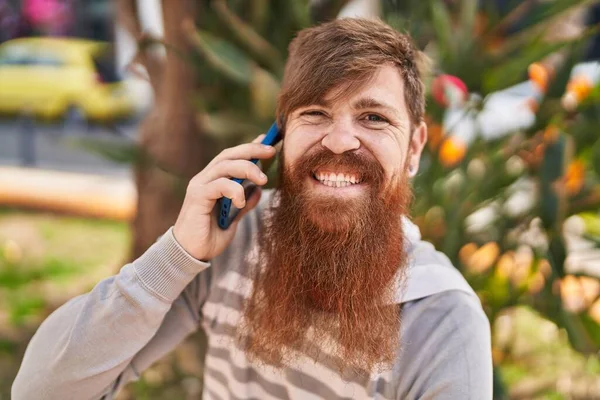 Νεαρός Κοκκινομάλλης Άντρας Χαμογελά Σίγουρος Μιλώντας Στο Smartphone Στο Πάρκο — Φωτογραφία Αρχείου