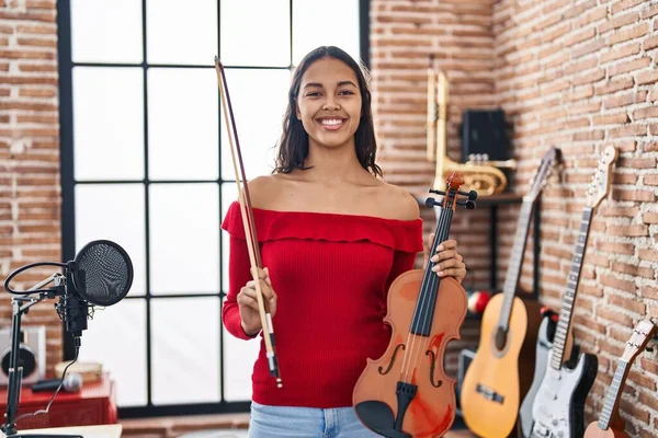年轻的非洲裔美国女音乐家带着自信的笑容在音乐工作室里握着小提琴 — 图库照片
