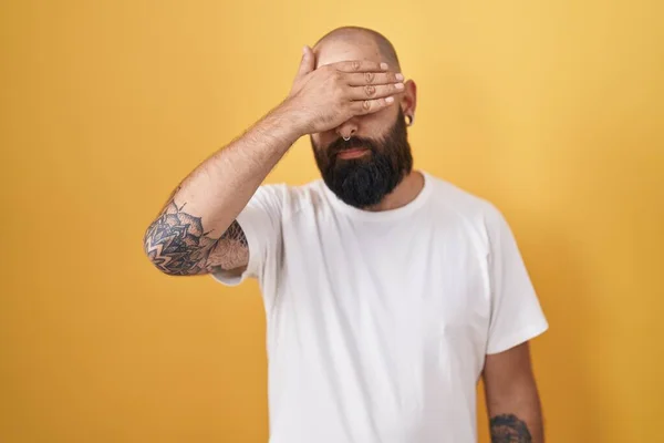 Young Hispanic Man Beard Tattoos Standing Yellow Background Covering Eyes — Stok fotoğraf
