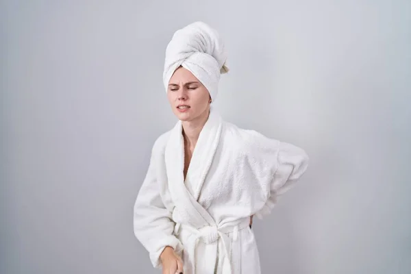 金发女人穿着浴衣 用手触摸 肌肉疼痛 — 图库照片