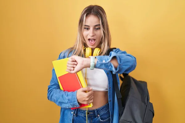 Young Blonde Woman Wearing Student Backpack Holding Books Looking Watch — Stok fotoğraf