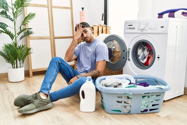 Young Hispanic Man Putting Dirty Laundry Washing Machine Surprised Hand — Stock Photo, Image