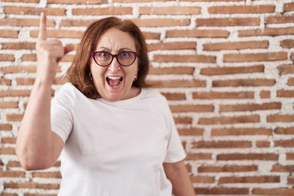 Duvarın Üzerinde Duran Gözlüklü Yaşlı Kadın Başarılı Bir Fikirle Işaret — Stok fotoğraf