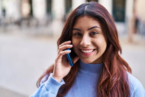 Genç İspanyol kadın gülümsüyor. Kendine güveniyor. Akıllı telefondan konuşuyor.