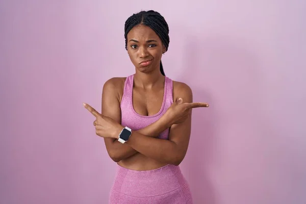 Африканская Американка Косичками Спортивной Одежде Розовом Фоне Указывающая Пальцами Обе — стоковое фото