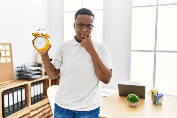 Young African Man Holding Alarm Clock Office Serious Face Thinking — Foto de Stock