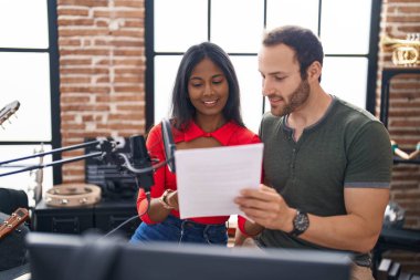 Man and woman musicians singing song at music studio