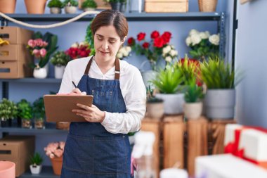 Çiçekçi dükkanında kendine güvenen genç bir çiçekçi.