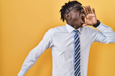 Sarı arka planda duran Afrikalı adam el ele tutuşmuş bağırıyor ve bağırıyordu. iletişim konsepti. 