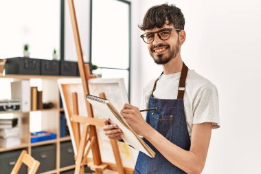 Resim stüdyosunda gülümseyen genç İspanyol sanatçı..