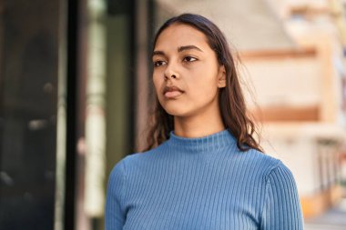 Rahat yüzü olan genç Afro-Amerikalı kadın sokakta dikiliyor.