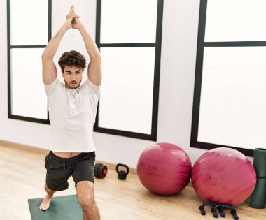 Genç İspanyol adam spor merkezinde yoga eğitimi alıyor.