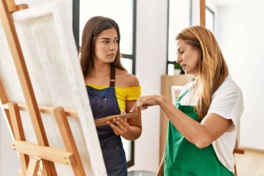 Anne ve kızı resim stüdyosunda resim çiziyor.