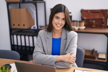 Genç ve güzel İspanyol iş kadını. Ofiste masasında kendinden emin bir şekilde oturuyor.