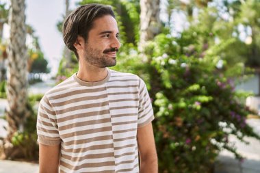 Young hispanic man smiling confident at park
