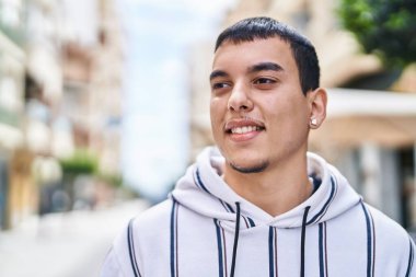 Sokakta kendine güvenen genç adam gülümsüyor