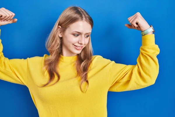 Young Caucasian Woman Standing Blue Background Showing Arms Muscles Smiling —  Fotos de Stock