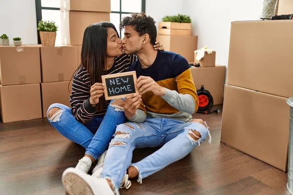 Young Latin Couple Holding New Home Blackboard Sitting Floor — Φωτογραφία Αρχείου