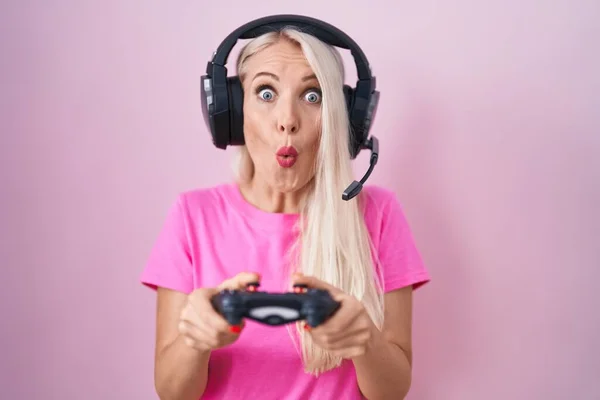 玩电子游戏的高加索女人手握着控制器 惊讶的表情 恐惧和兴奋的脸 — 图库照片