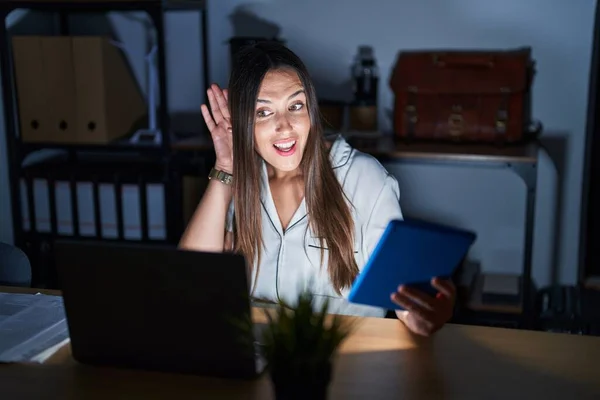 Young Brunette Woman Working Office Night Smiling Hand Ear Listening — Fotografia de Stock